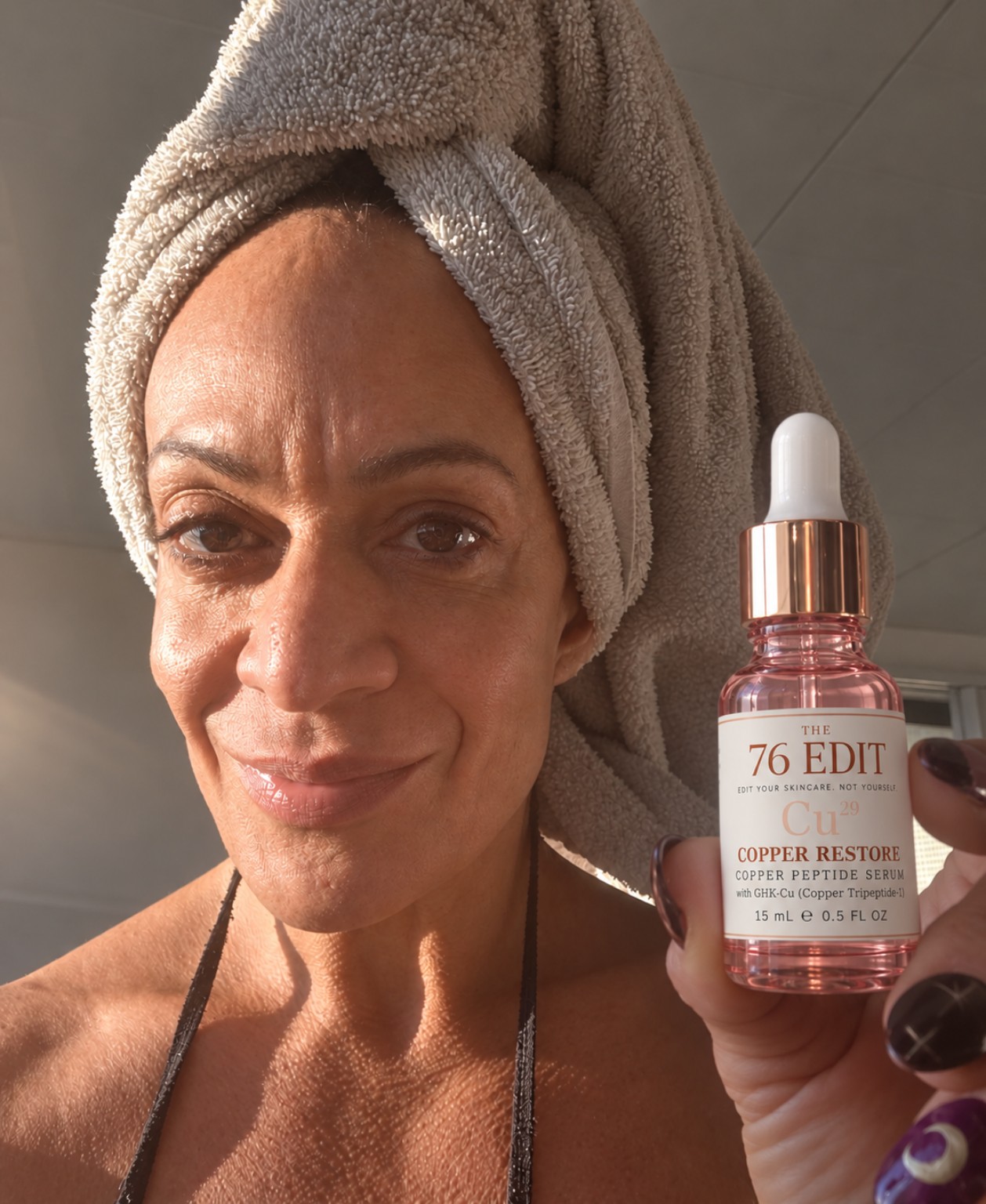 Tara holding Copper Restore Serum in natural light